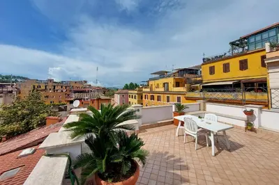 a balcony with a table and chairs on a roof at Magic Trastevere suite on roof terrace in Rome