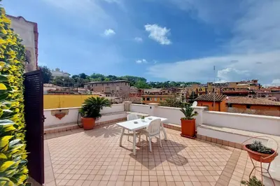 a patio with a table and chairs on a balcony at Magic Trastevere suite on roof terrace in Rome