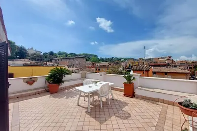a patio with a table and chairs on a balcony at Magic Trastevere suite on roof terrace in Rome