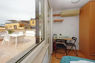 a room with a balcony with a table and chairs at Magic Trastevere suite on roof terrace in Rome