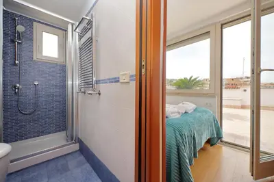 a bathroom with a shower and a bed in it at Magic Trastevere suite on roof terrace in Rome