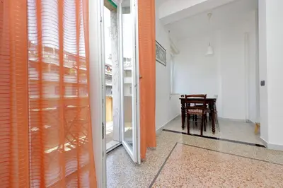 an orange curtain in a room with a table at Silvano's Home In Rome in Rome