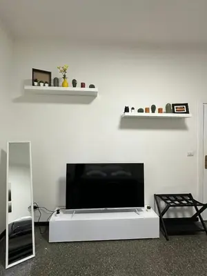 a living room with a flat screen tv on a white wall at Cozy House Roma - San Giovanni in Rome