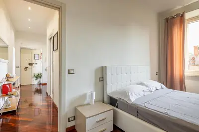 a bedroom with a large white bed and a window at Attico vista San Pietro, vicino ai Musei Vaticani in Rome