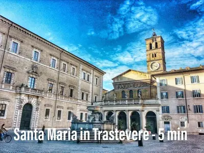 a large building with a clock tower in front of it at Khris Home Apartments - Trastevere - San Cosimato in Rome