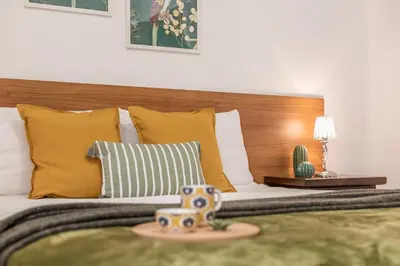 a bed with yellow pillows and a wooden headboard at Hope Home in Rome