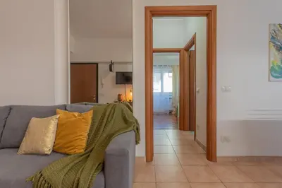 a living room with a gray couch with a green blanket at Hope Home in Rome