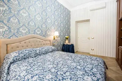 a bedroom with a blue and white patterned wall at Apartment Glatimia -Your Home In The Heart Of Rome in Rome
