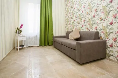 a living room with a couch and green curtains at Apartment Glatimia -Your Home In The Heart Of Rome in Rome
