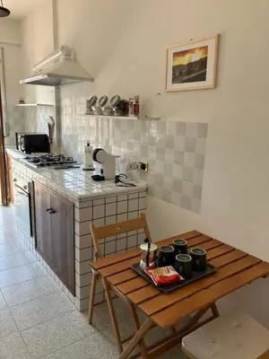 a kitchen with a wooden table and a stove top oven at Ulisse home in Rome