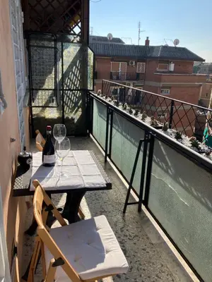 a balcony with a table and wine glasses on it at Ulisse home in Rome