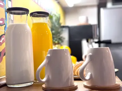 two bottles of milk and two cups on a table at Appartamento Metro A e Vaticano Maroma in Rome