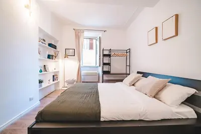 a bedroom with a large bed with white walls at Cosy Colosseum in Rome