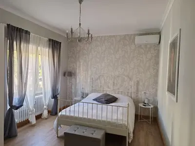 a bedroom with a white bed and a chandelier at S Peter suite appartamento ristrutturato in centro in Rome