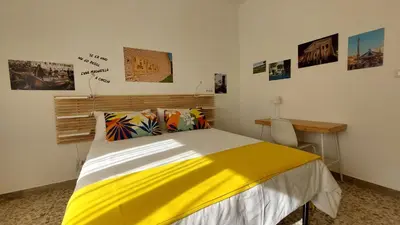 a bedroom with a bed and a desk and pictures on the wall at Way of Saying CASA in Rome