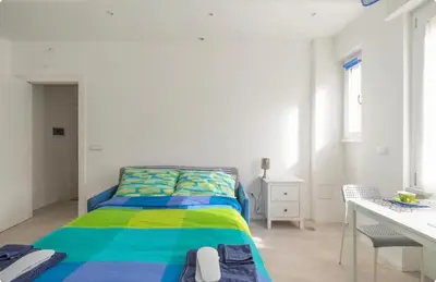 a bedroom with a bed with a colorful bedspread at luminoso spazio nel barocchetto romano in Rome