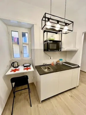 a small kitchen with a sink and a chair at Pamphili Home - Un angolo di pace vicino Trastevere in Rome