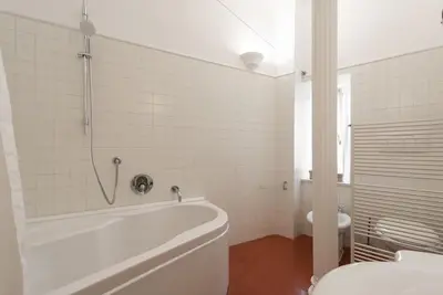 a white bathroom with a tub and a toilet at Colosseum Number sixteen apartment in Rome