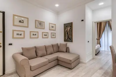 a living room with a couch and paintings on the wall at Ciancaleoni Gruppo M&L Apartments in Rome