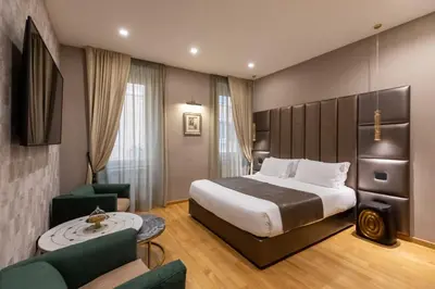 a room with two chairs and a table and a bed at Ara di Marte Home in Rome