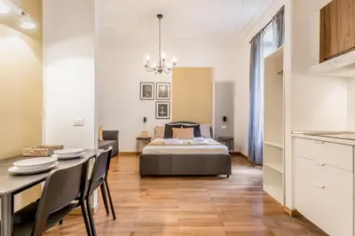 a bedroom with a bed and a table and chairs at Palazzo Sapienza Design Suites in Rome
