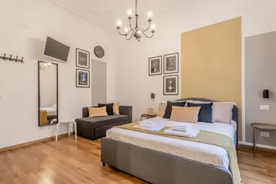 a bedroom with a large bed and a chair at Palazzo Sapienza Design Suites in Rome