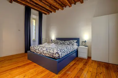 a bedroom with a blue bed and a wooden floor at Cozy Flat Orso Navona square in Rome