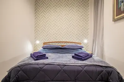 a bedroom with a bed with purple pillows on it at Borgo Vittorio 76 in Rome