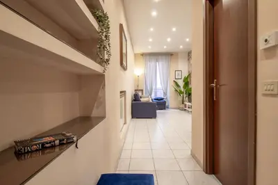 a hallway leading to a living room with a blue couch at Borgo Vittorio 76 in Rome