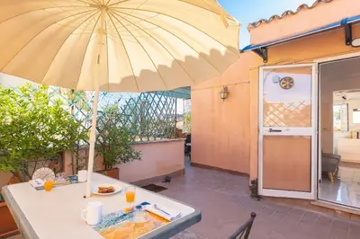 a table with an umbrella on a patio at Centro Piccolo attico da sogno in Rome