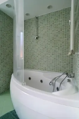 a white bath tub in a bathroom with green tiles at La Dolce Vita rooms in Rome