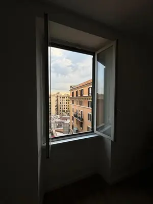 an open window with a view of a city at La Dolce Vita rooms in Rome