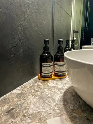 three bottles of alcohol sitting on a counter in a bathroom at Vatican Boutique - 1 bedroom Apartment - Bilocale in Rome