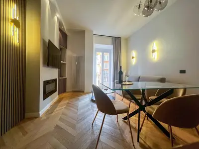 a living room with a glass table and chairs at Vatican Boutique - 1 bedroom Apartment - Bilocale in Rome