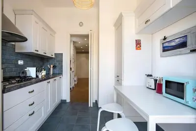 a kitchen with white cabinets and a white counter top at AndreaSuite Gianicolo in Rome