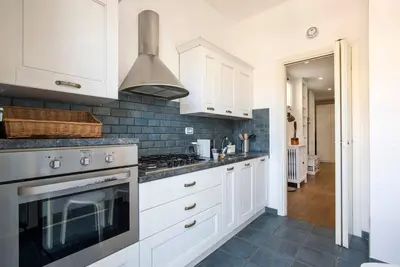 a kitchen with white cabinets and a stove top oven at AndreaSuite Gianicolo in Rome