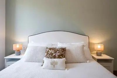 a white bed with pillows and two lamps at AndreaSuite Gianicolo in Rome