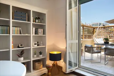 a room with a book shelf with a table and a balcony at AndreaSuite Gianicolo in Rome
