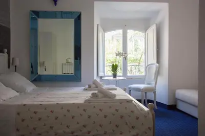a bedroom with a bed with a mirror and a chair at Deluxe Vatican in Rome