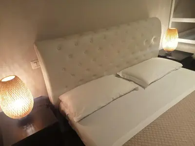a white bed with two lamps and two pillows at Deluxe Vatican in Rome