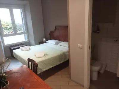 a bedroom with a bed and a toilet and a window at Deluxe Vatican in Rome