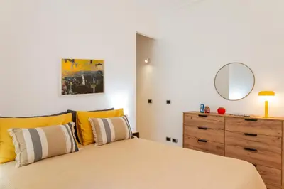 a bedroom with a bed and a dresser with a mirror at Casa Porta Metronia in Rome
