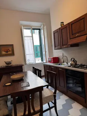 a kitchen with a wooden table and a kitchen counters at Casa Angeli in Rome