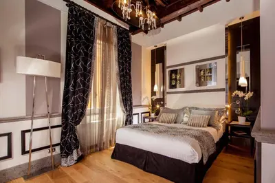 a bedroom with a bed and a large window at The Inn at the Spanish Steps Luxury Collection - Suite Condotti in Rome