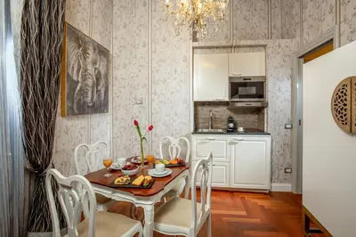 a kitchen and dining room with a table and chairs at The Inn at the Spanish Steps Luxury Collection - Suite Condotti in Rome