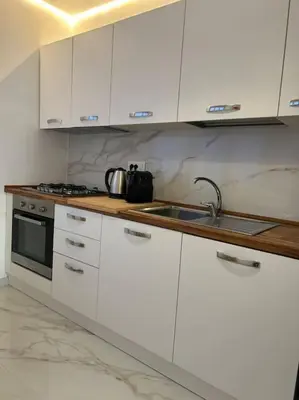 a kitchen with white cabinets and a sink at A casa di Leo in Rome