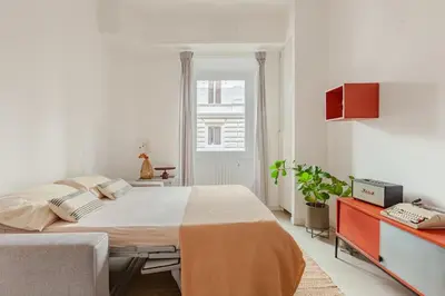 a white bedroom with a large bed and a window at Appartamento moderno a due passi dal Colosseo in Rome