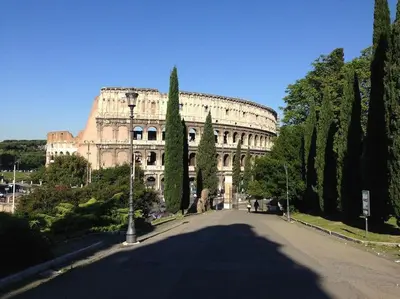 a large building with trees in front of a road at Appartamento moderno a due passi dal Colosseo in Rome