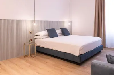 a bedroom with a large bed and a chair at Tiburtina 86 Luxury Suites in Rome