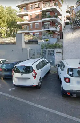 two cars parked in a parking lot in front of a building at L aROMA ANTICA in Rome